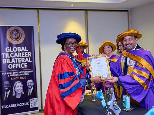 Honorary doctorate recipient receiving a certificate from London Tilcareer Institute